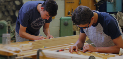 Students work on woodworking equipment